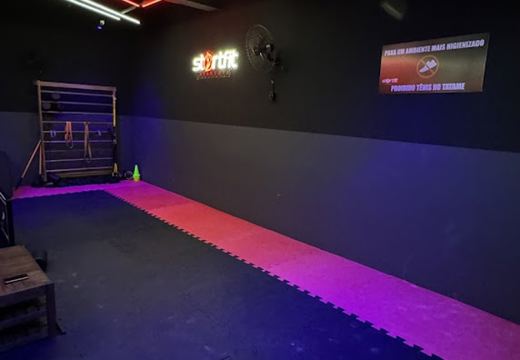 Área com tatame e materiais para mobilidade e alongamento.