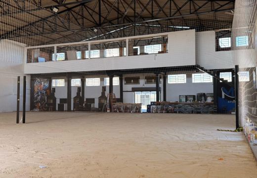 Vista do espaço coberto da MB Sports, com quadra de areia, bar, churrasqueiras e área de convivência.